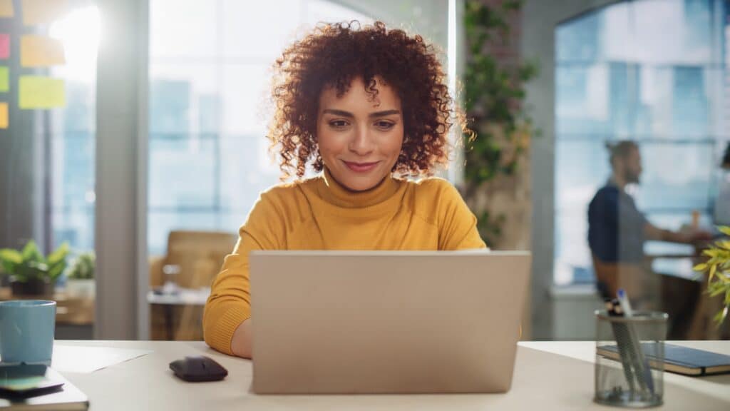 young woman on laptop investing and budgeting finances