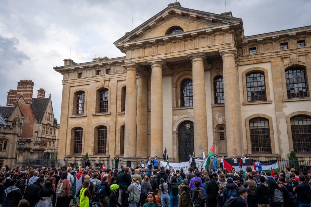 A crowd listens to speakers at the Dr Ghassan Abu-Sittah rally outside Oxford University building.