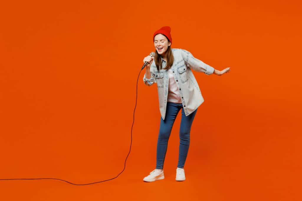 Woman doing karaoke, orange background