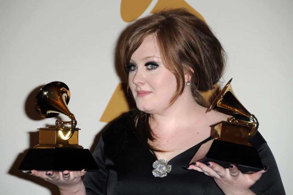 Adele holding two Brit awards she won in 2011.
