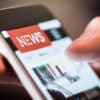 A close up of browsing online news on a mobile phone.