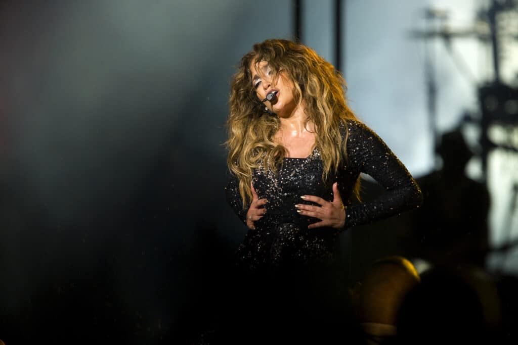 Jennifer Lopez singing and dancing on stage.