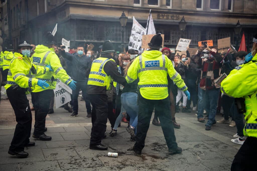 Police taking away protestors in the UK.