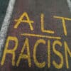 Chalk written on pavement in opposition to racist Nazi and alt-right ideology of Agartha and Hyperborea