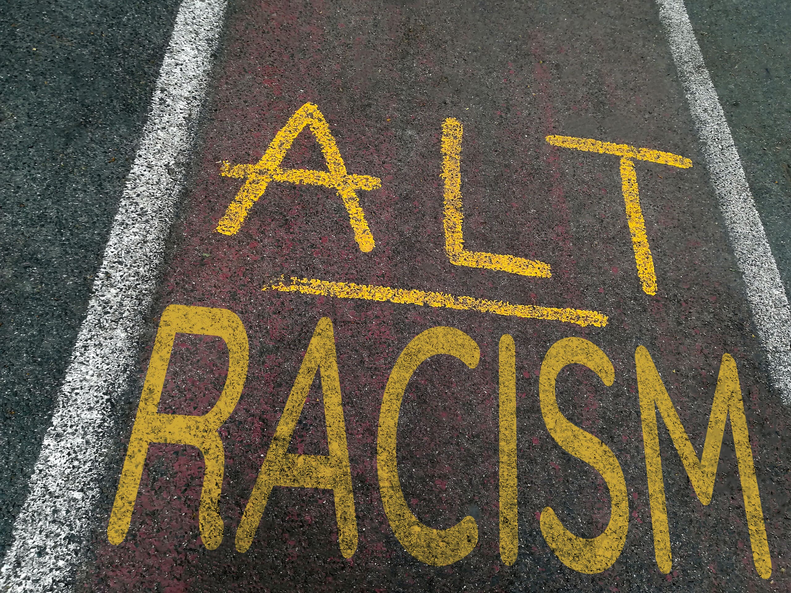 Chalk written on pavement in opposition to racist Nazi and alt-right ideology of Agartha and Hyperborea