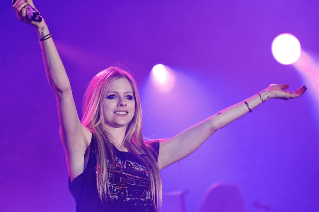 Avril Lavigne on stage at a concert.