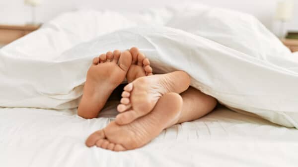 couple's feet cuddling in bed