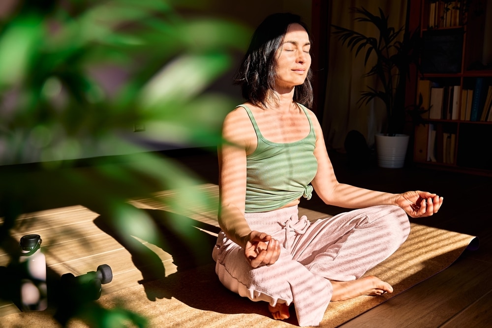 girl meditating in front of window