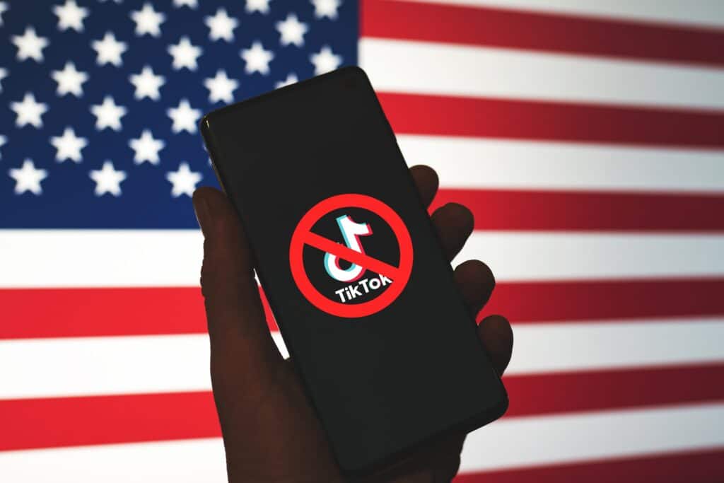 TikTok logo crossed out with US flag in background.