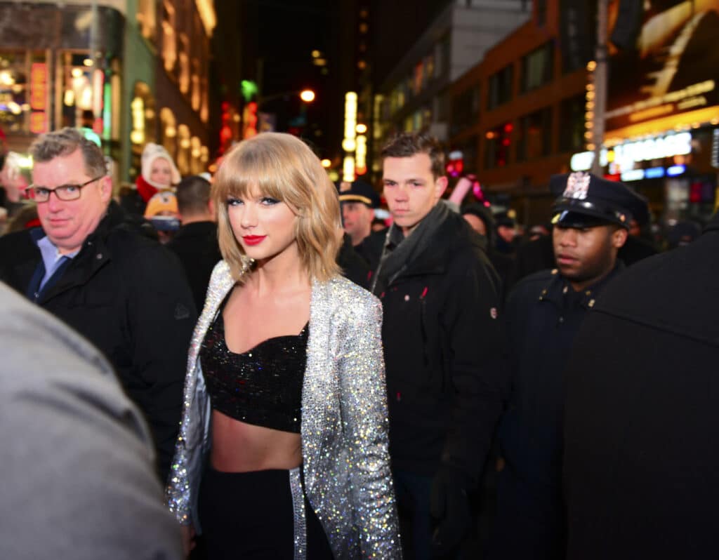 A Taylor Swift paparazzi photo from 2014. She has short hair, and is wearing a silver jacket.