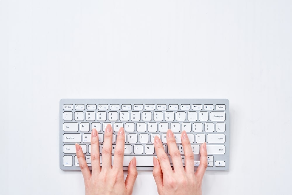 woman's hands typing on keyboard