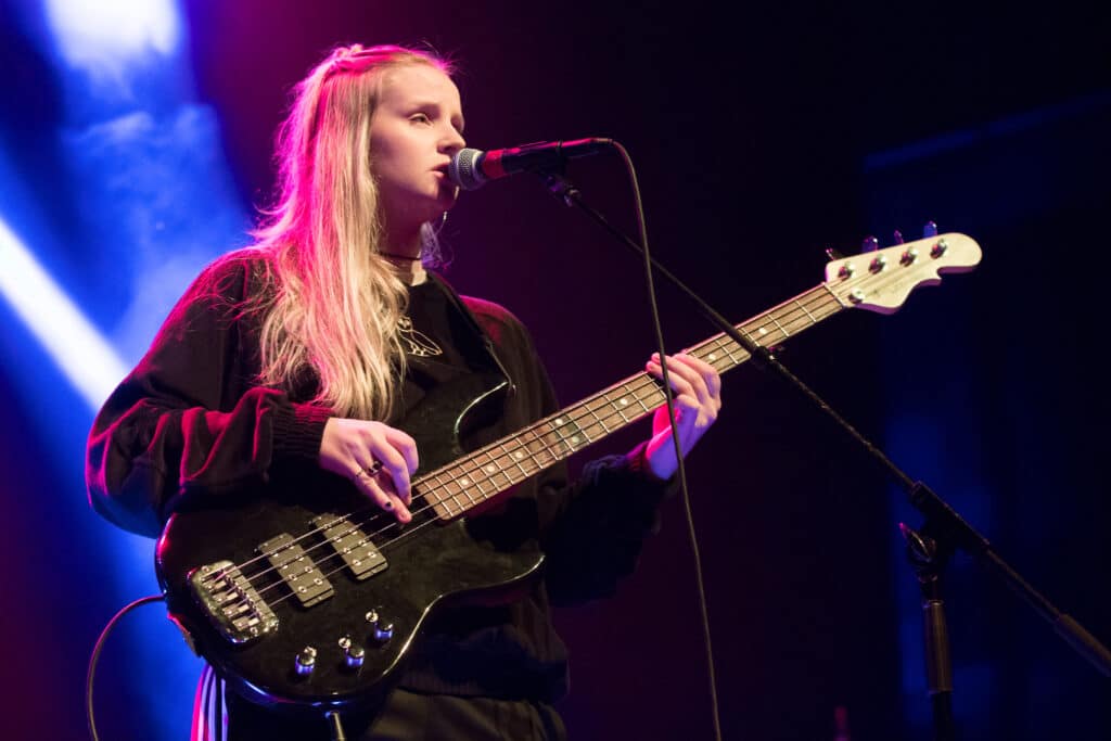 Charlotte Day Wilson singing and playing her guitar on stage.