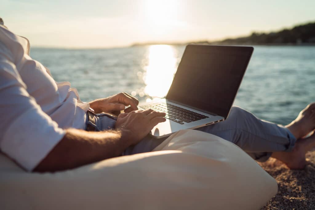 man working on laptop at the beach