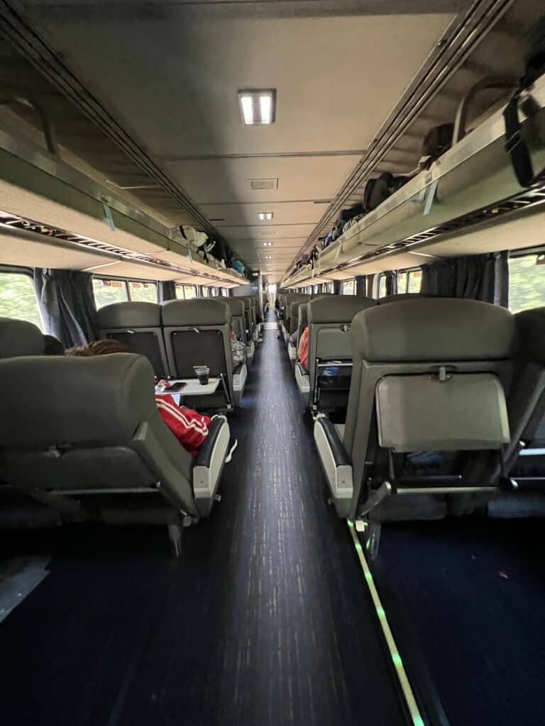 Coach seating. Two-by-two seats, with bag storage above.