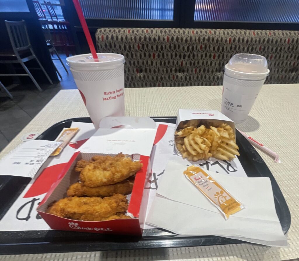 Chick-fil-a chicken meal with two drinks on a tray.