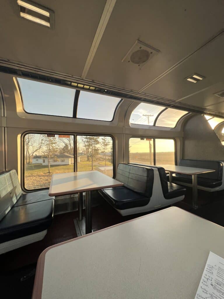 Empty panorama car at golden hour. Window view is a White House surrounded by trees and an open road leading south.