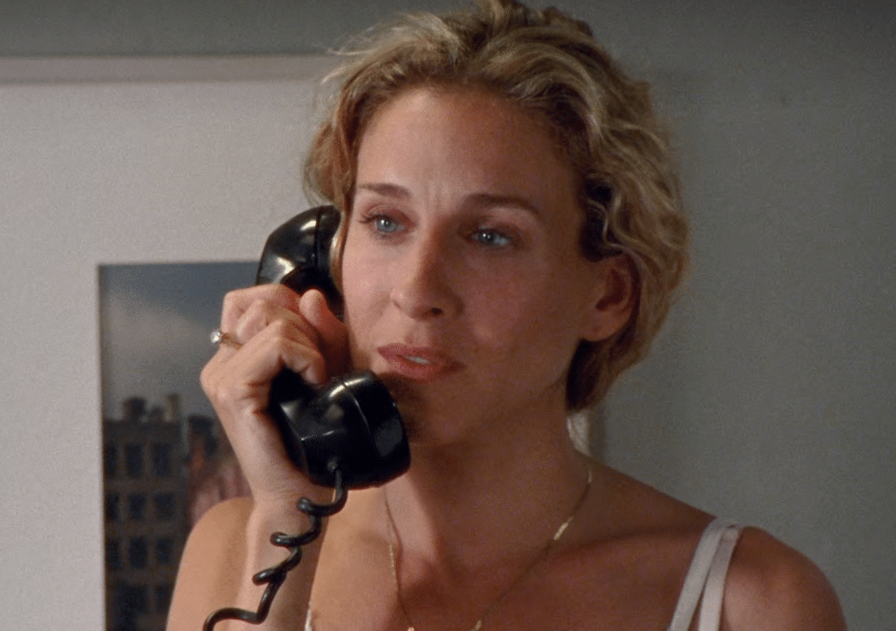 A still shot of Carrie Bradshaw talking on a corded landline phone in Sex and the City.