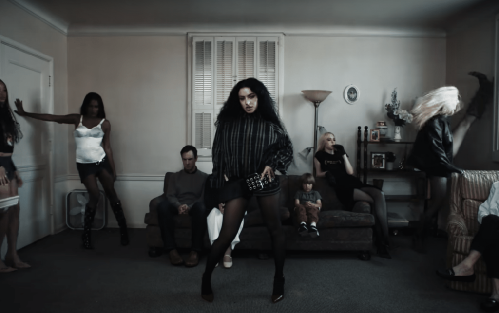 A screenshot of Charli Xcx in a suburban family home in the music video for "360".