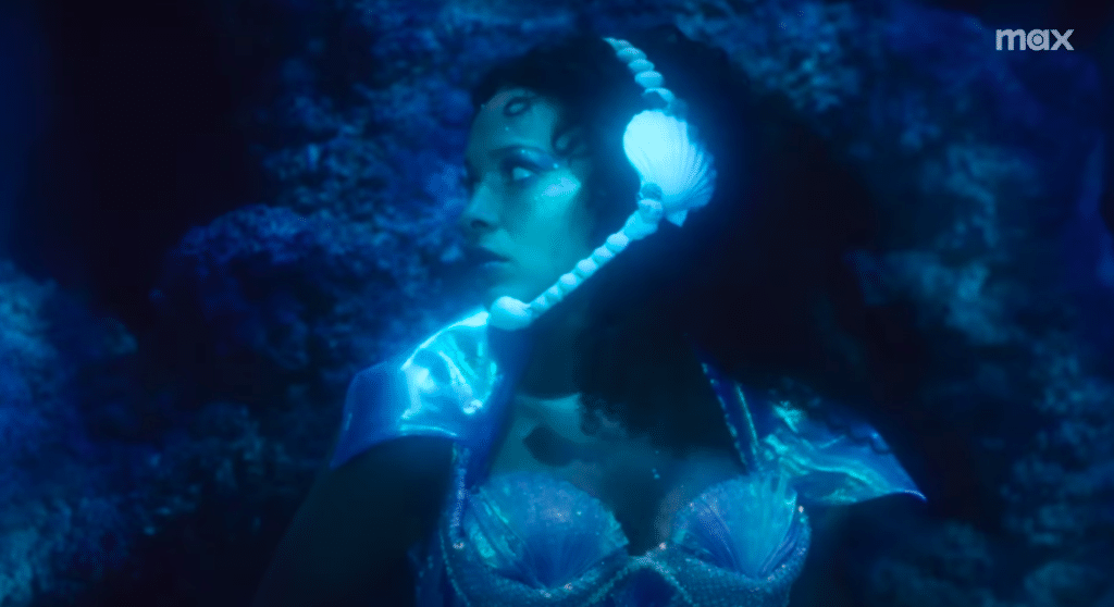 Princess Nokia is underwater and wearing a seashell headset.