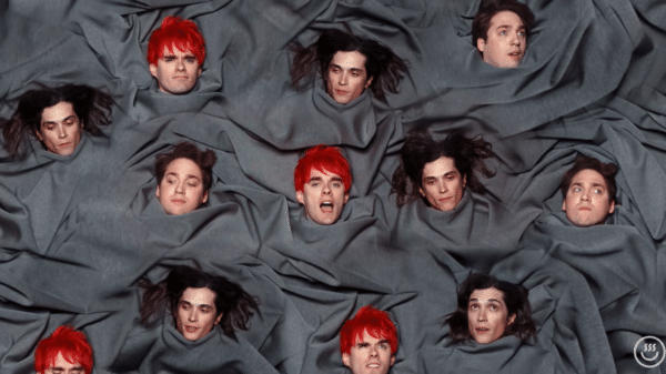 Clip of FUNERAL GREY music video with multiple Awsten, Otto, and Geoff heads on a grey sheet
