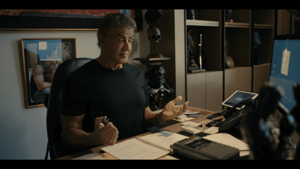 Sylvester Stallone at his desk reviewing his thought process through screenwriting the Rocky movie.