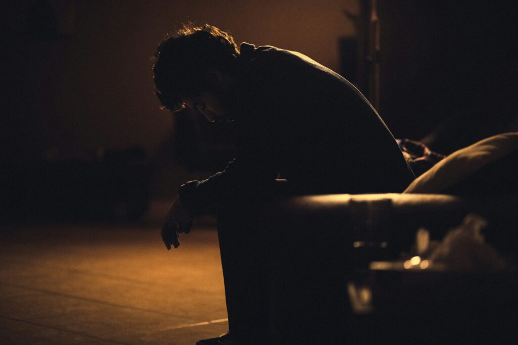 Despondent man hunched on a couch