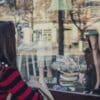 a woman longingly looking at fashion items through a store window