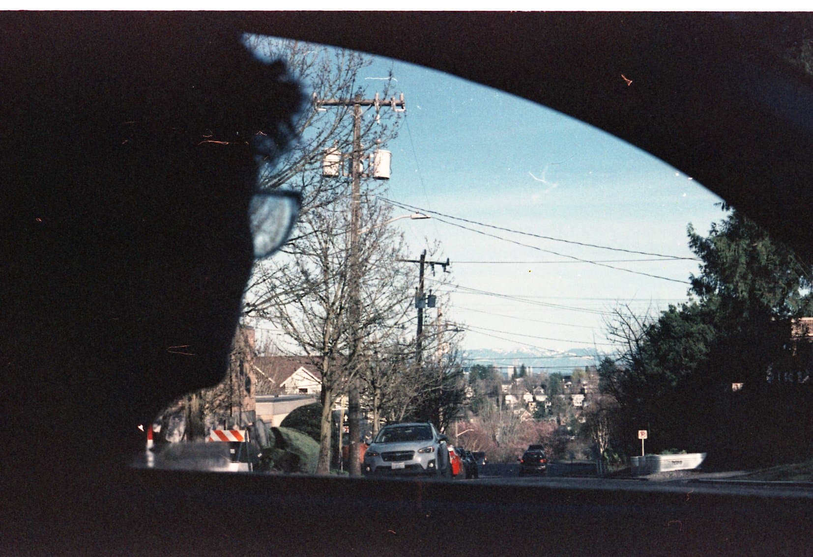 A man looks out the window of a car towards Seattle's Mount Rainier