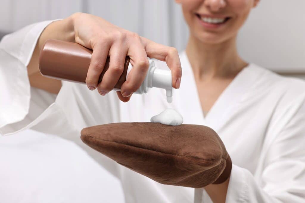 Woman holding self-tanning lotion