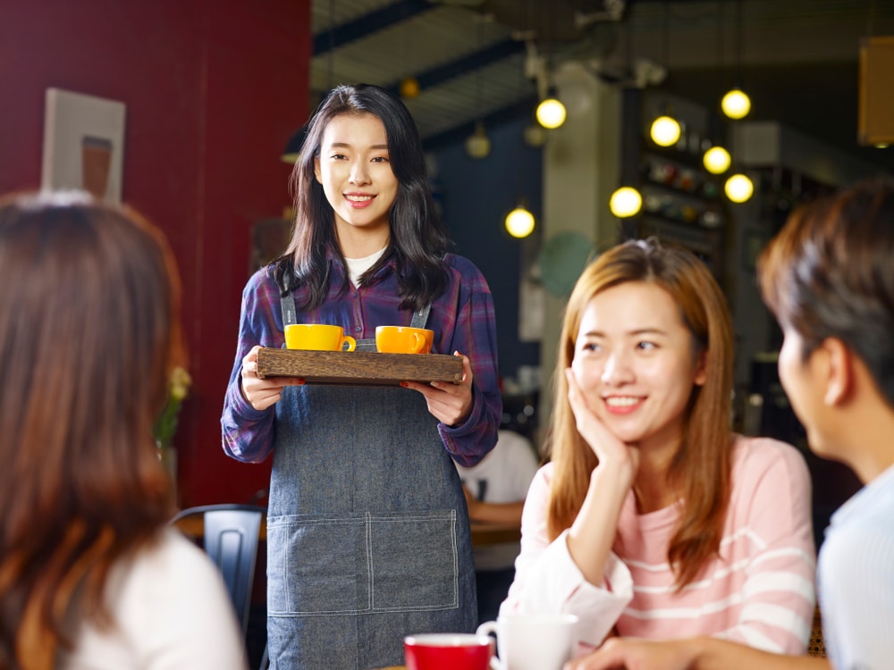 A waitress serving customers in a coffee shop.