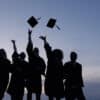 Silhouette,Of,Graduating,Students,Throwing,Caps,In,The,Air.