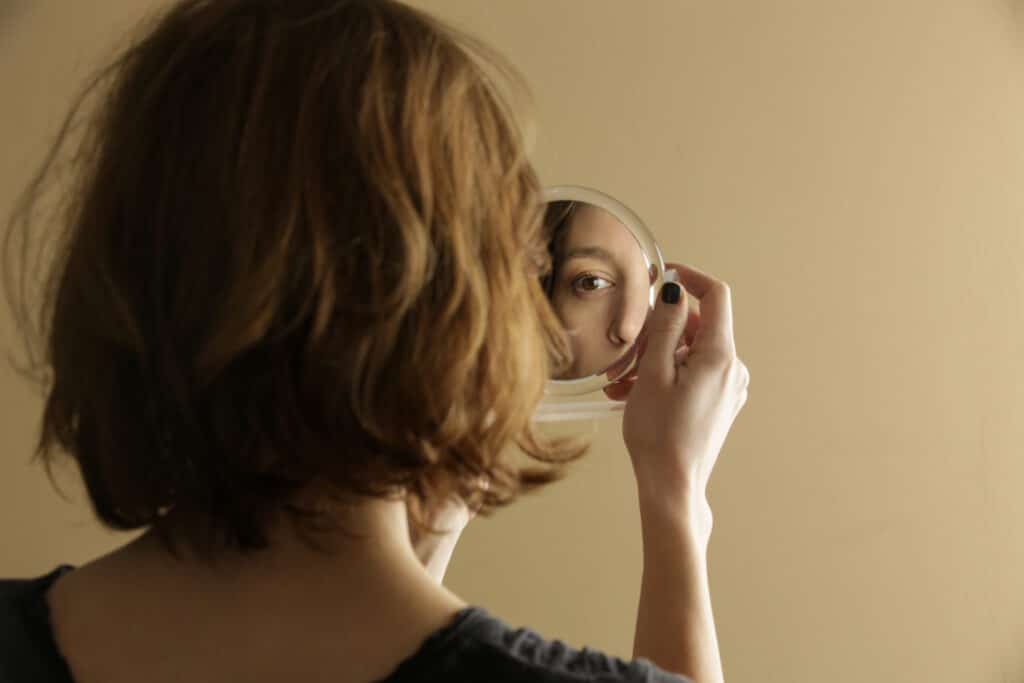 Woman looking at her reflection in a mirror