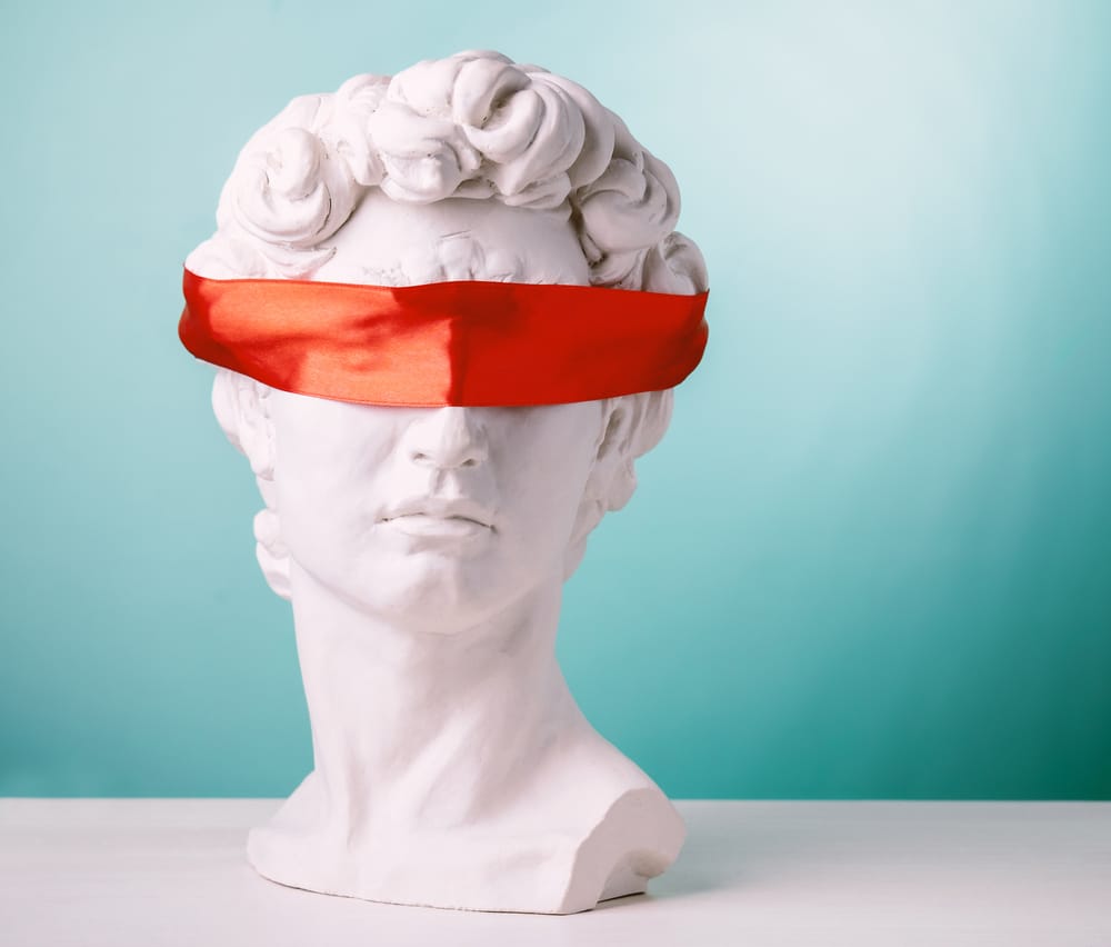 a statue head with a red blindfold