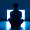 The Male Sitting On The Floor In Front Of TV