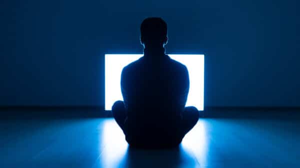 The Male Sitting On The Floor In Front Of TV