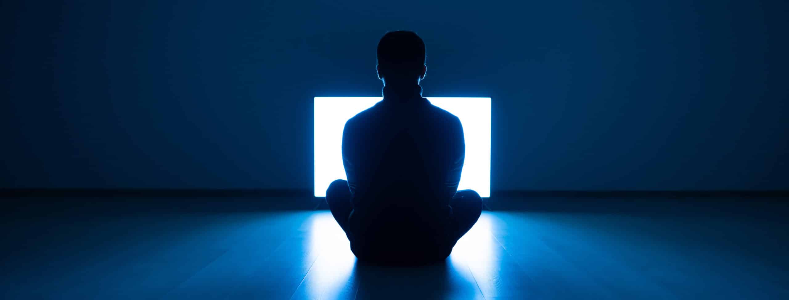 The Male Sitting On The Floor In Front Of TV