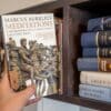 Reader pulls out a book on Stoicism by Marcus Aurelius; a book that is a favorite within the Manosphere.