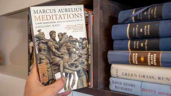 Reader pulls out a book on Stoicism by Marcus Aurelius; a book that is a favorite within the Manosphere.