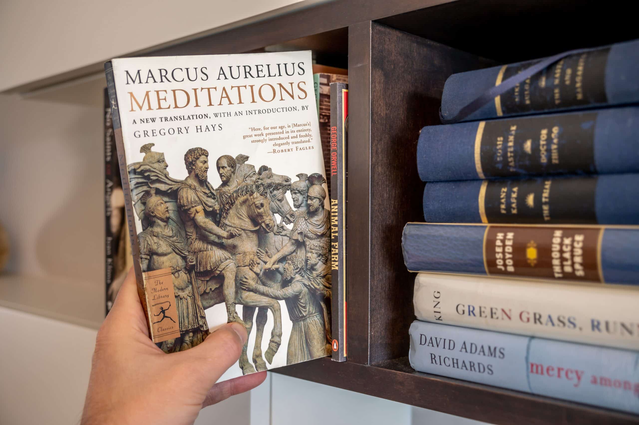 Reader pulls out a book on Stoicism by Marcus Aurelius; a book that is a favorite within the Manosphere.