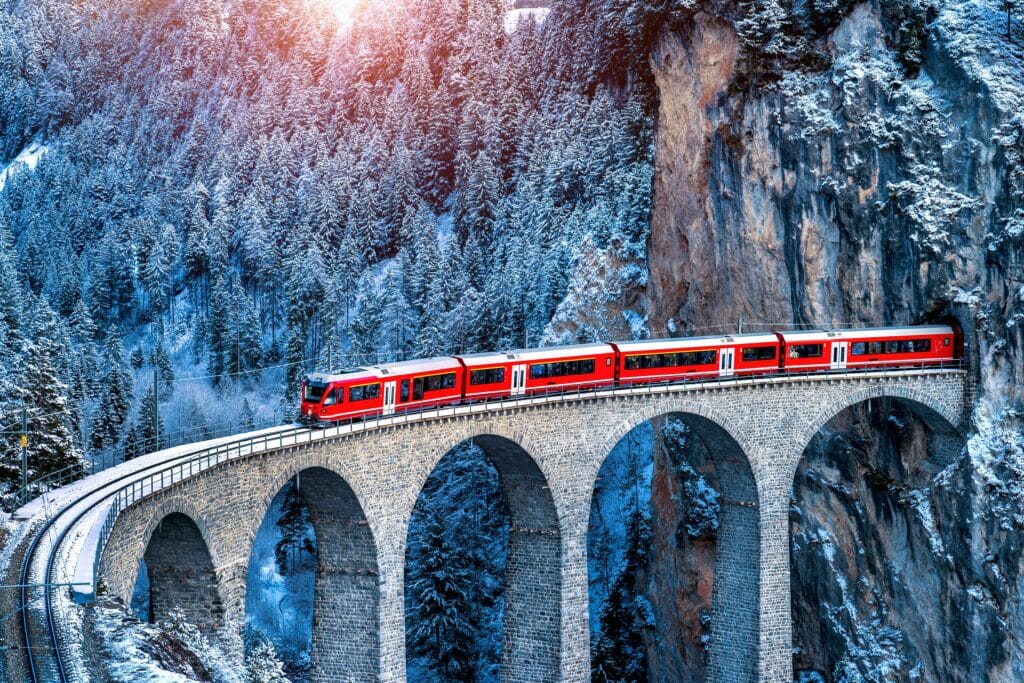 Aerial view of Train passing through Swiss Alps snowy mountain in Filisur, Switzerland.