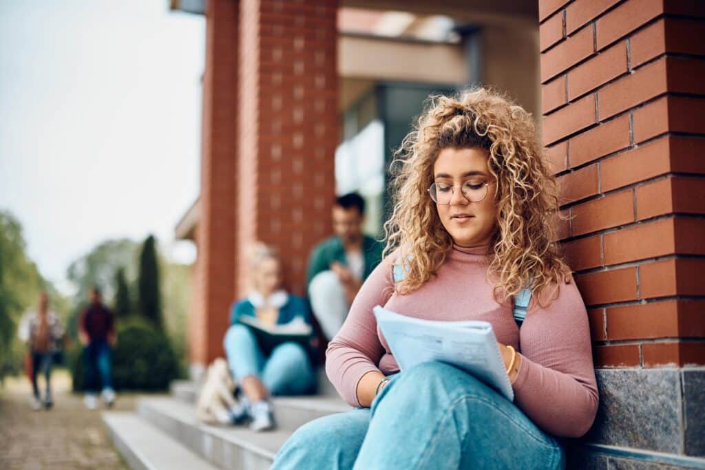 College woman working on homework outside