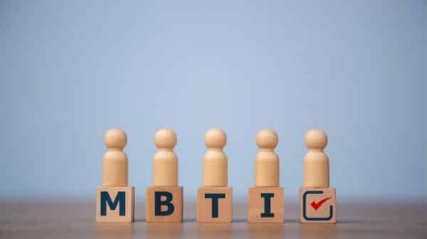 blocks with "mbti" lettering on a table with wooden people figurines