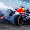 Max Verstappen's car releasing smoke from the rear in the 2023 Abu Dhabi Grand Prix
