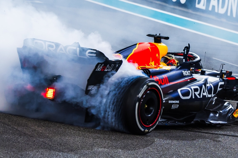 Max Verstappen's car releasing smoke from the rear in the 2023 Abu Dhabi Grand Prix