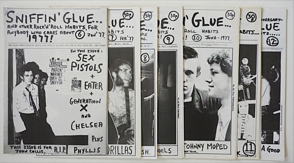 A flatlay of multiple issues of Sniffin' Glue. They are black and white.