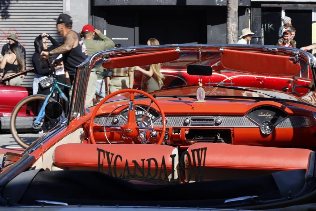 Red, leather interior of lowrider. Virgin Mary on dashboard.