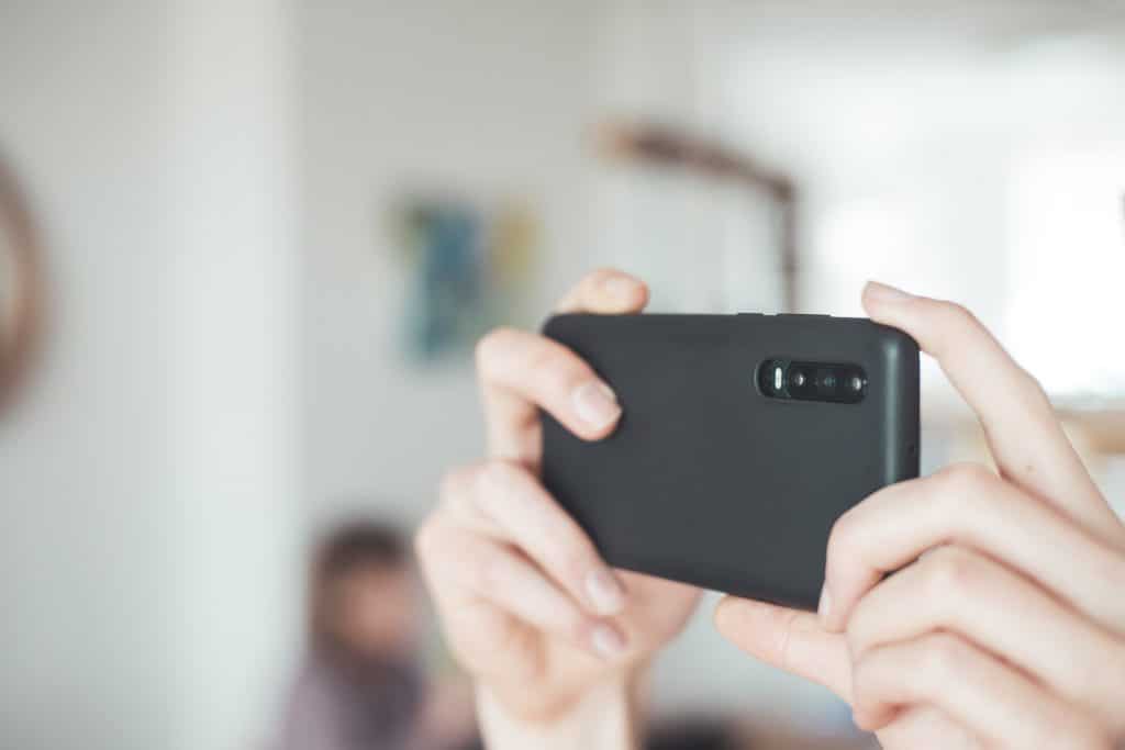 Close up of a black smartphone camera taking photos in a uni house
