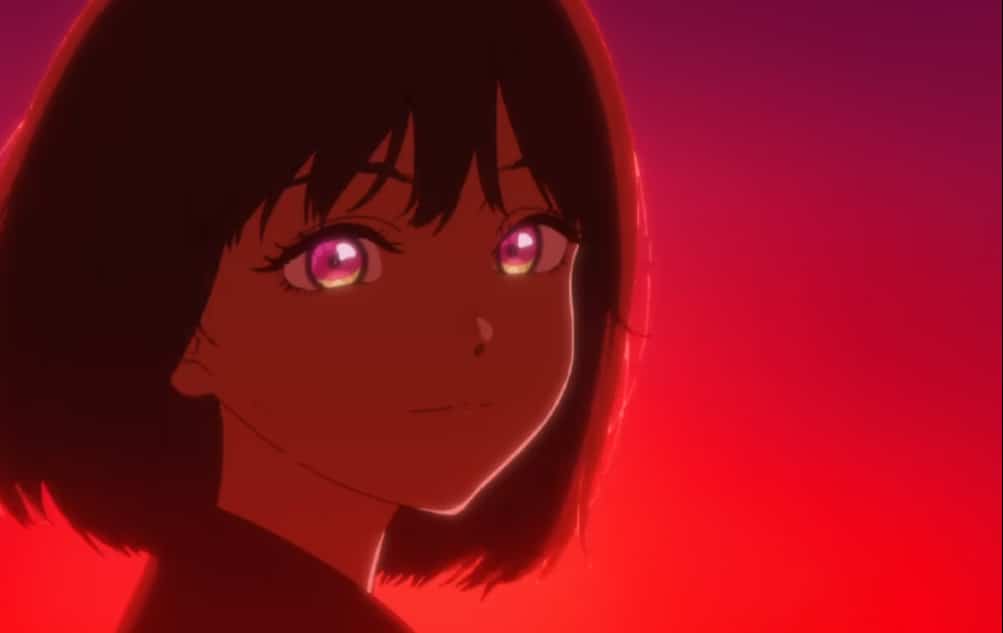 Osanai smiles at viewer, her face and background highlighted in a vivid angry red.