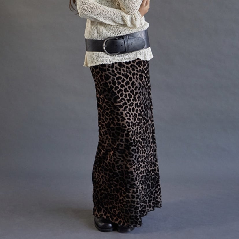 Motel Rocks model wearing a white sweater with a chunky black belt and a long leopard-print skirt