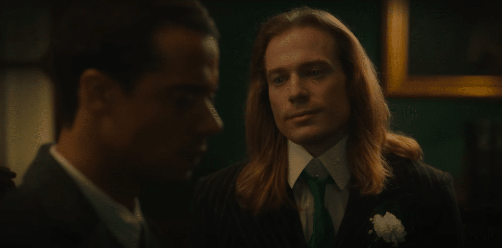 Louis and Lestat are sitting in an office together. Lestat is gazing lovingly at Louis while Louis is looking away.
